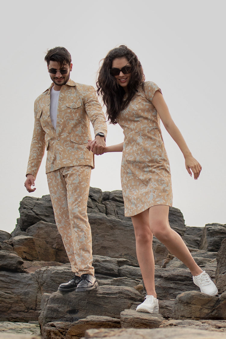 Two people in matching floral outfits standing on rocky terrain.slider_item_BaBtDC