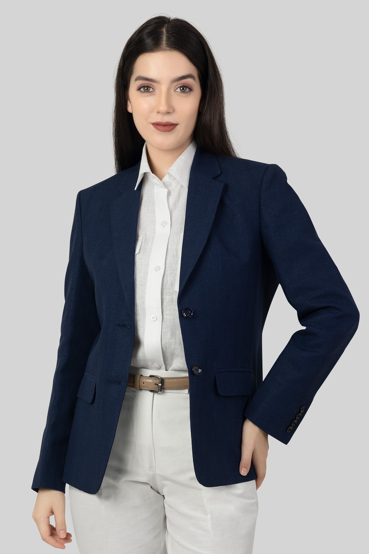 A woman modeling a blue linen blazer with a notch lapel, two-button single-breasted design, and flap pockets.