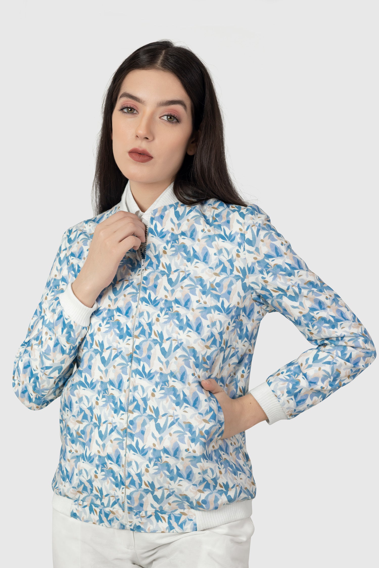 Woman wearing a blue and white floral patterned shirt on a white background