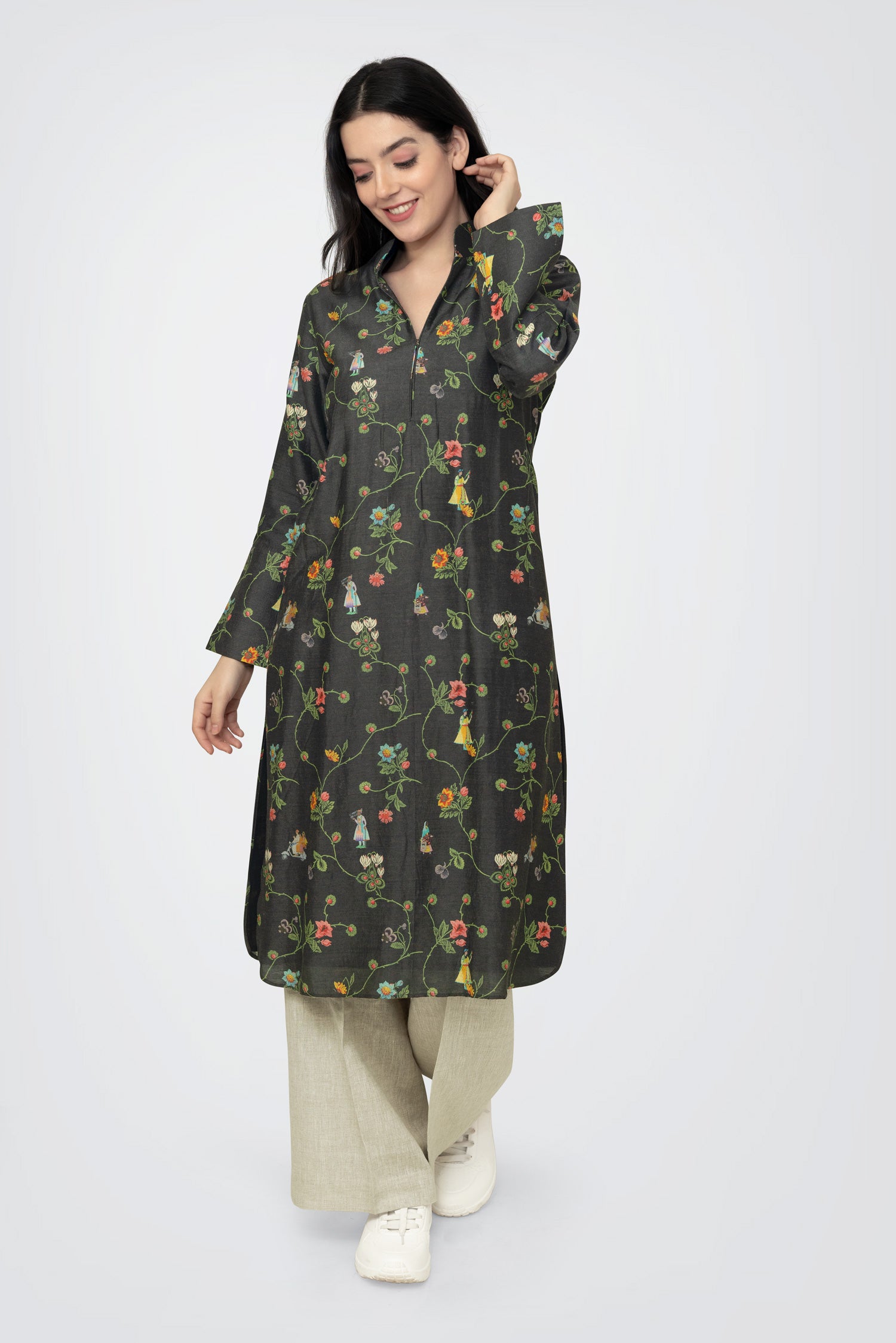 A woman standing against a white background, wearing a floral print long sleeve kurta with a mandarin collar and a V-shaped neck.