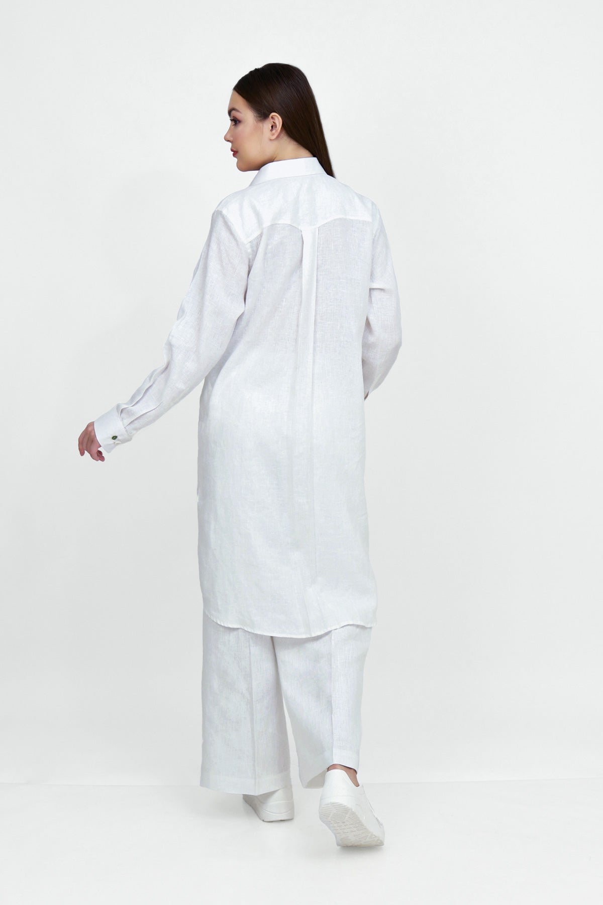 Woman wearing a white shirt and pants on a white background