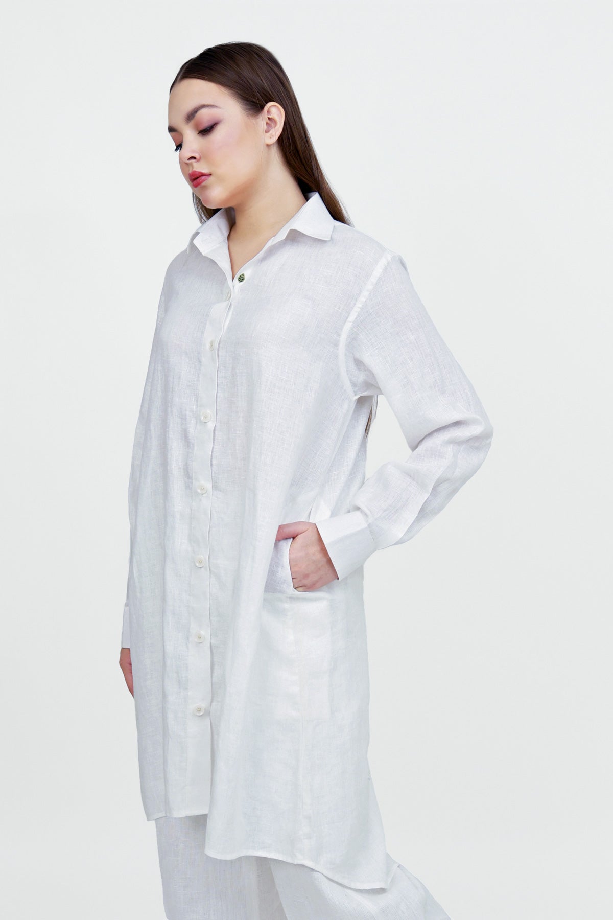 Woman wearing a long white shirt on a white background