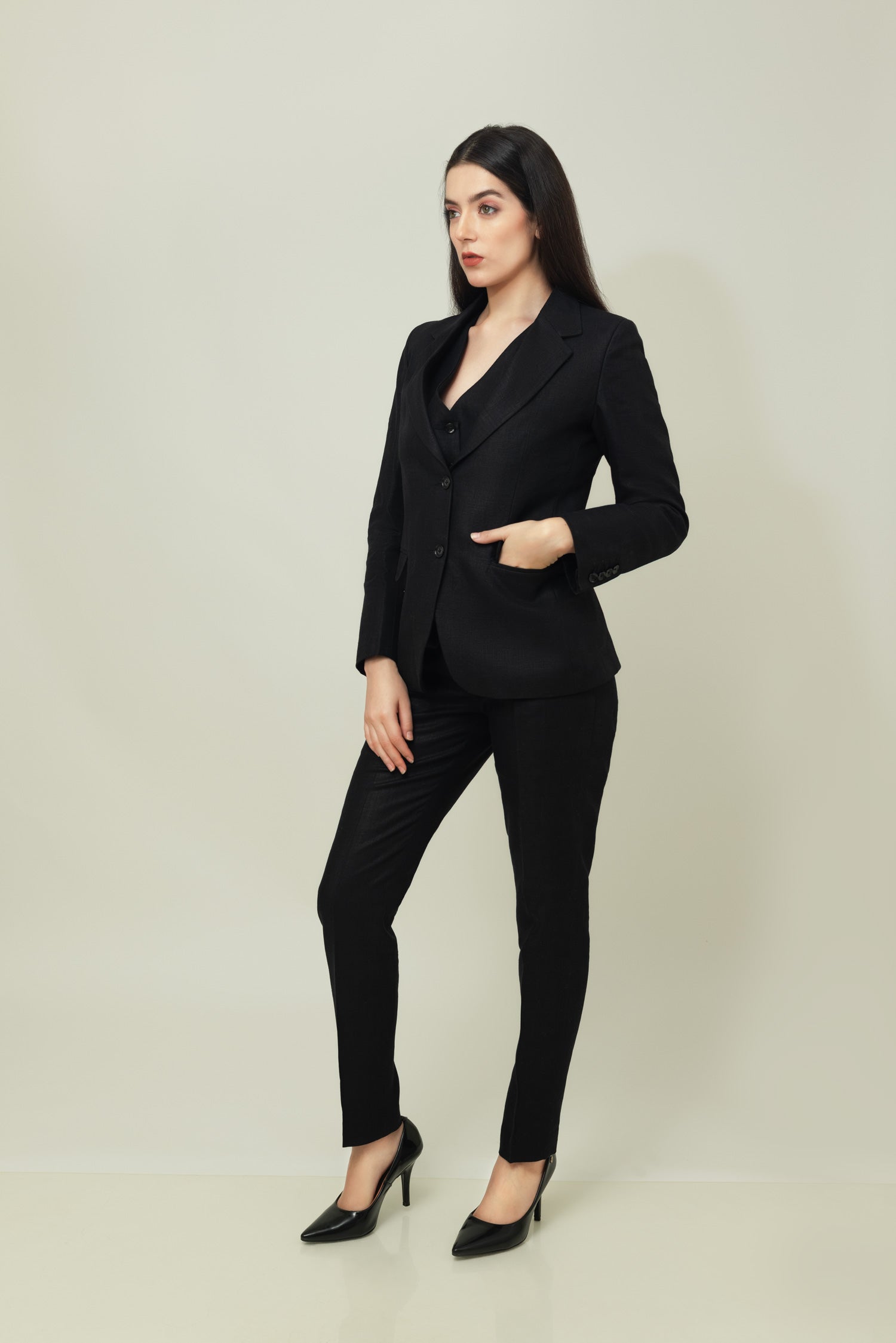 A woman modeling a black linen blazer with a notch lapel, two-button single-breasted design, and flap pockets.