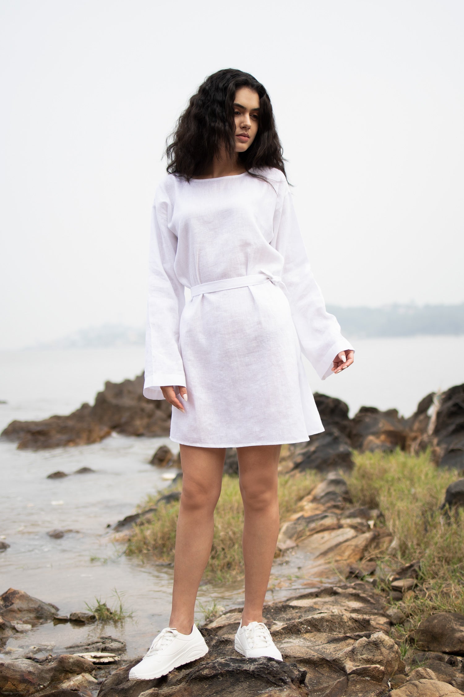 Women wearing white long top with long sleeves near beach