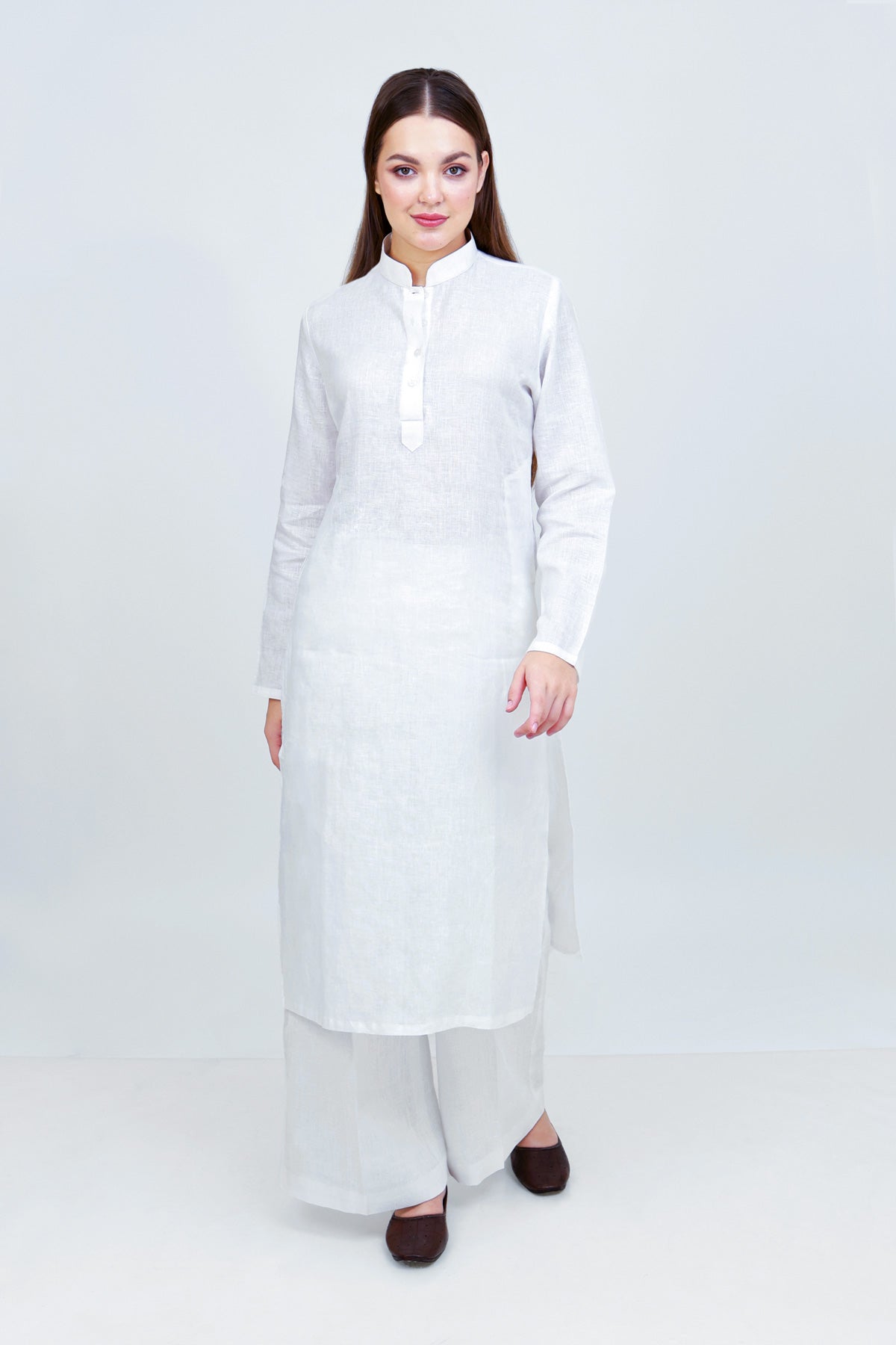 Woman wearing a long white dress against a white background