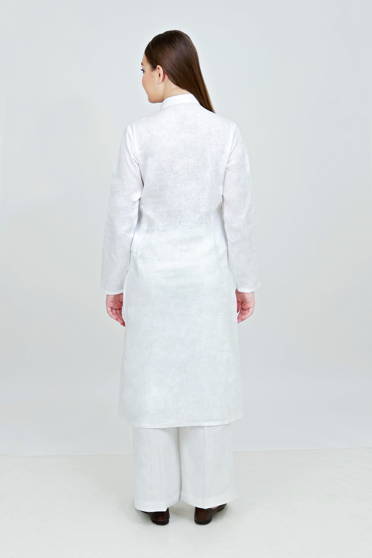 Person wearing a white coat and pants on a white background