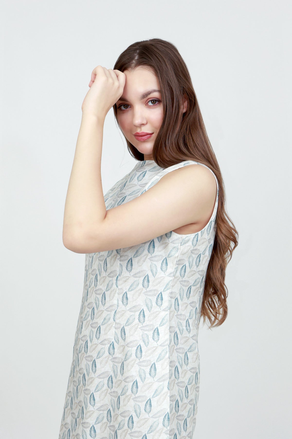 Woman wearing a sleeveless dress with a white background