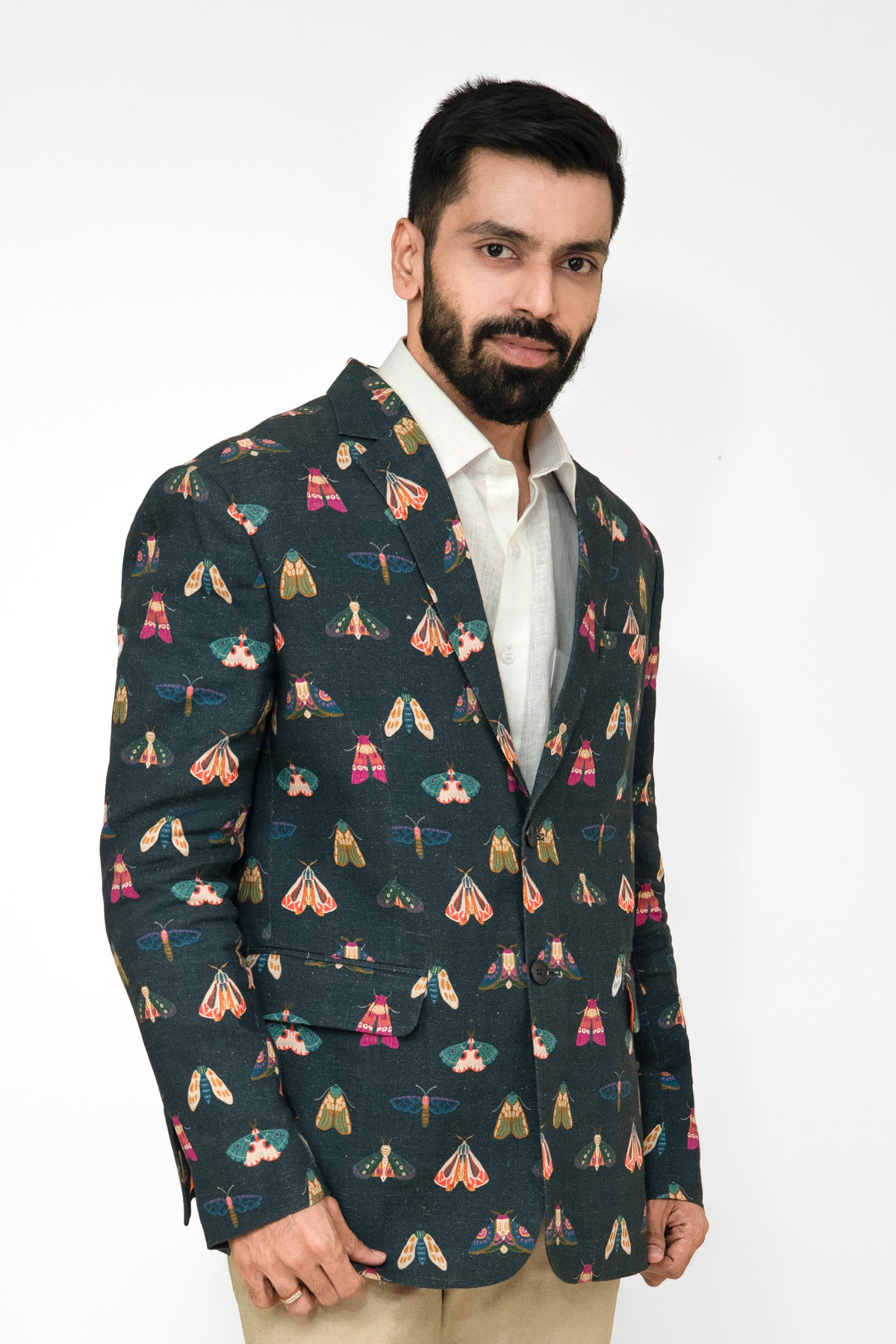 Man wearing a butterfly printed blazer on a white background