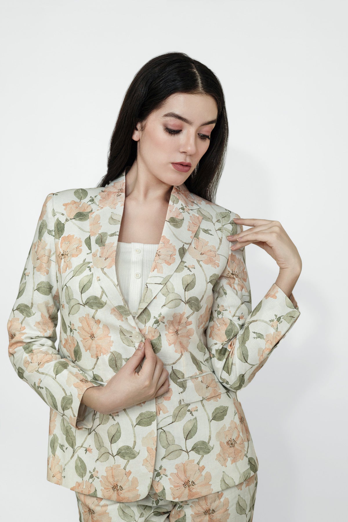 Woman wearing a floral blazer and pants on a white background