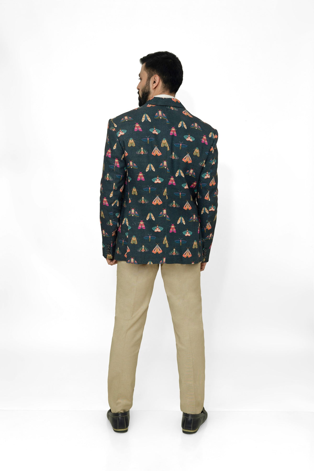 Man wearing a butterfly printed blazer on a white background