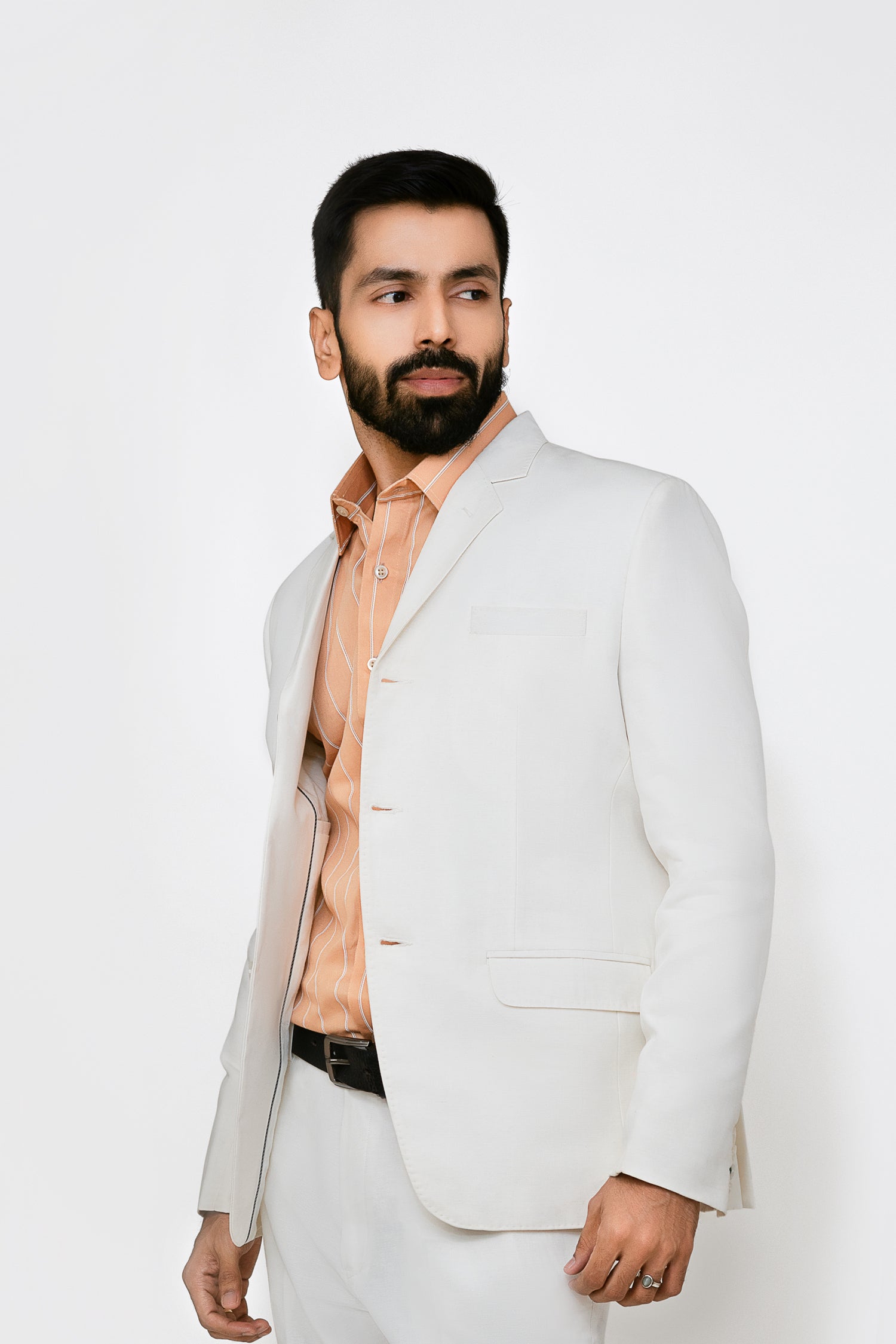 A male model wearing a white hemp blazer with a notch lapel, three buttons, two flap pockets and a chest pocket. The blazer is fully lined with a cotton satin interior.