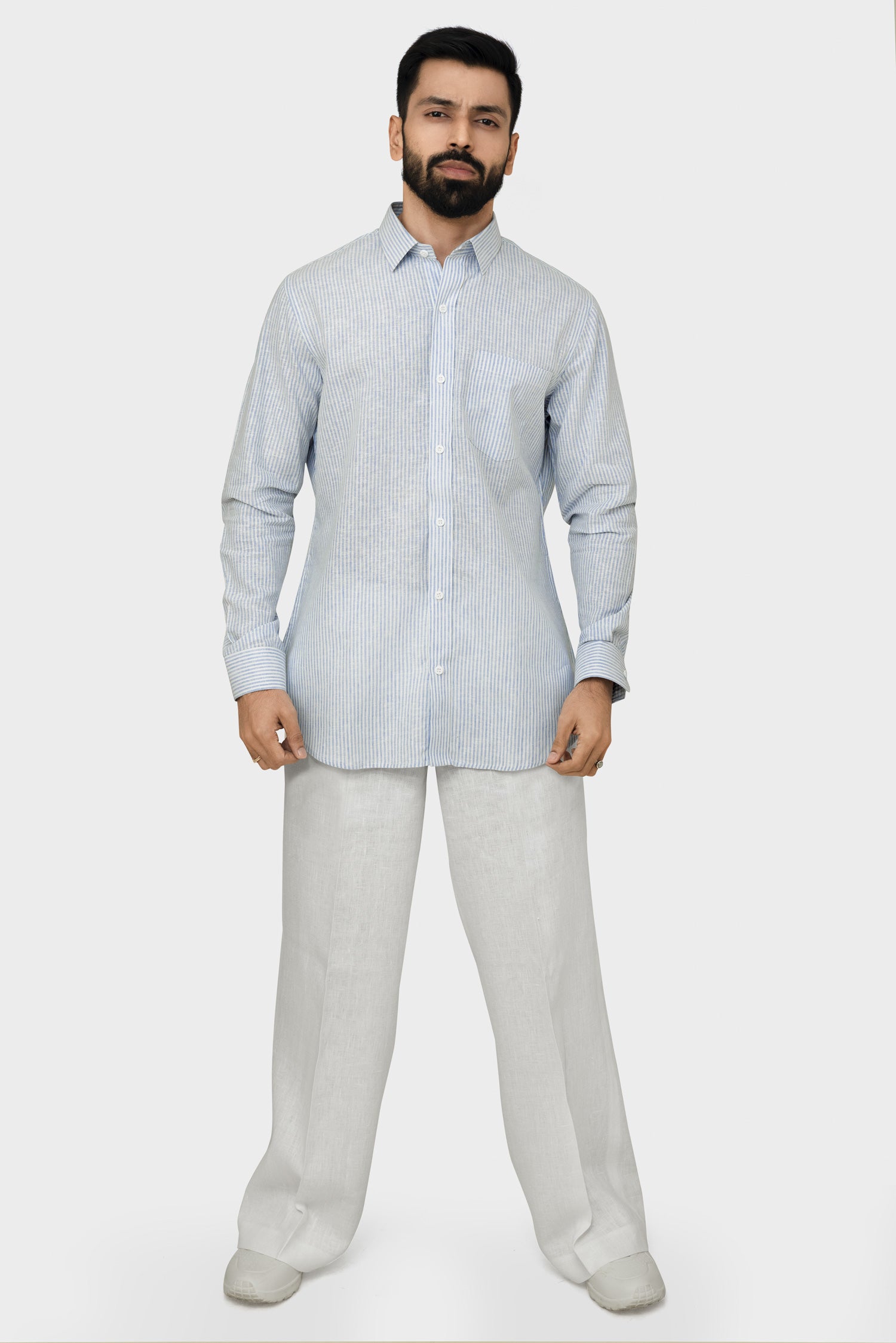 Man wearing a light blue kurta and pants on a white background