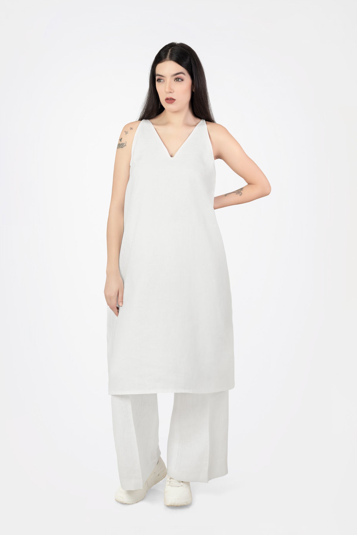 Woman wearing a white sleeveless dress on a white background
