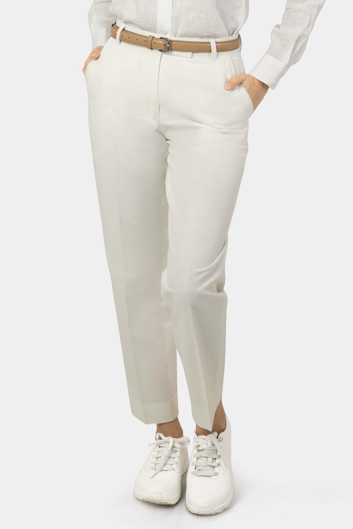 A pair of white women's hemp trousers with a belt, slanting front pockets, and jetted back pockets, featuring a hook and bar closure at the waistband and a zip fly.