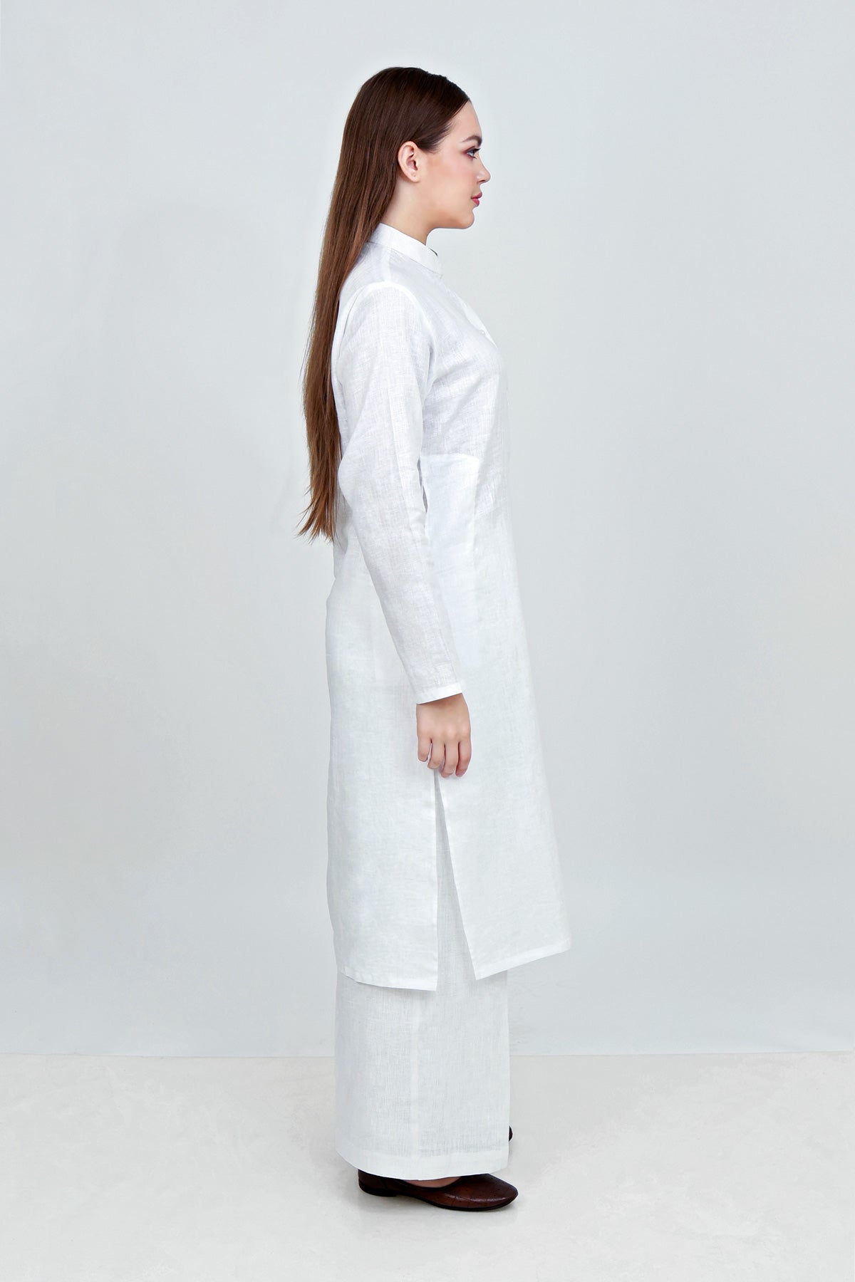 Woman wearing a white lab coat on a plain background