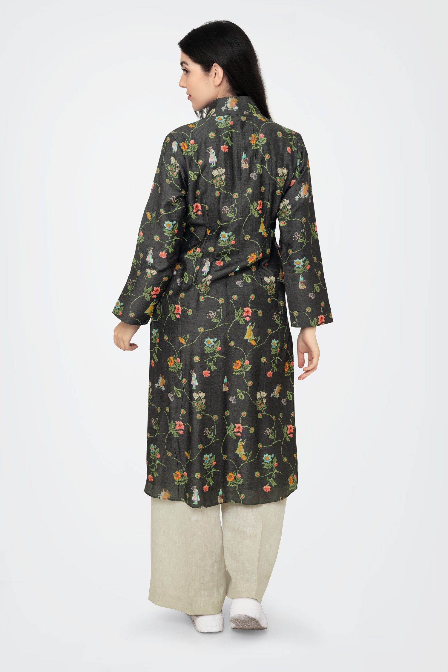 A woman standing against a white background, wearing a floral print long sleeve kurta with a mandarin collar and a V-shaped neck.