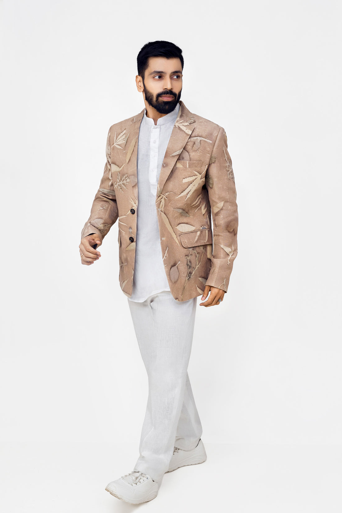 A men wearing brown eco-print blazer with whire shirt and trousers in white background. 