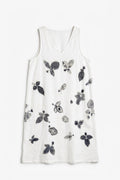A sleeveless white V-neck dress with a scattered black and gray botanical leaf print, displayed flat against a white background.