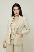A woman modeling a beige linen blazer with a notch lapel, two-button single-breasted design, and flap pockets.