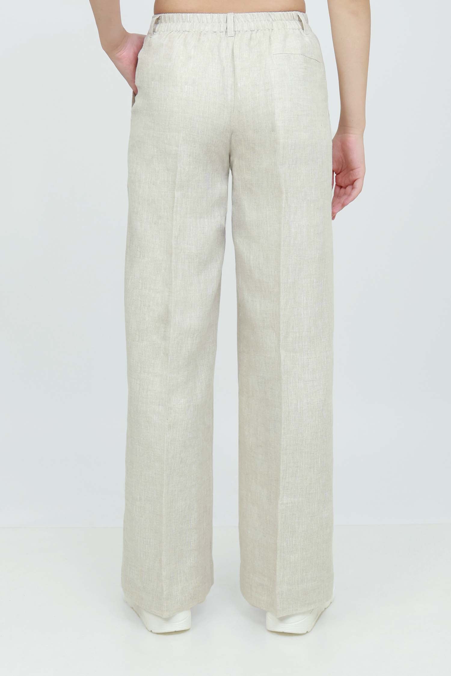 A pair of beige wide-leg trousers with a mid-rise waist, front buttons, and a relaxed fit. The trousers are fully lined and have a hook and bar closure at the waistband with an adjustable elastic belt.