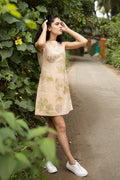 Woman in a floral dress standing on a path surrounded by greenery