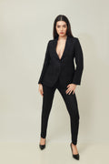 A woman modeling a black linen blazer with a notch lapel, two-button single-breasted design, and flap pockets.