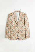 A men's single-breasted linen blazer with a beige base and an all-over abstract floral pattern in pink, orange, and gray, displayed flat against a white background.
