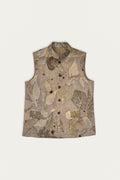 A sleeveless beige hemp vest with an all-over botanical leaf print in shades of brown, beige, and muted green, featuring a mandarin collar and a button-down front.