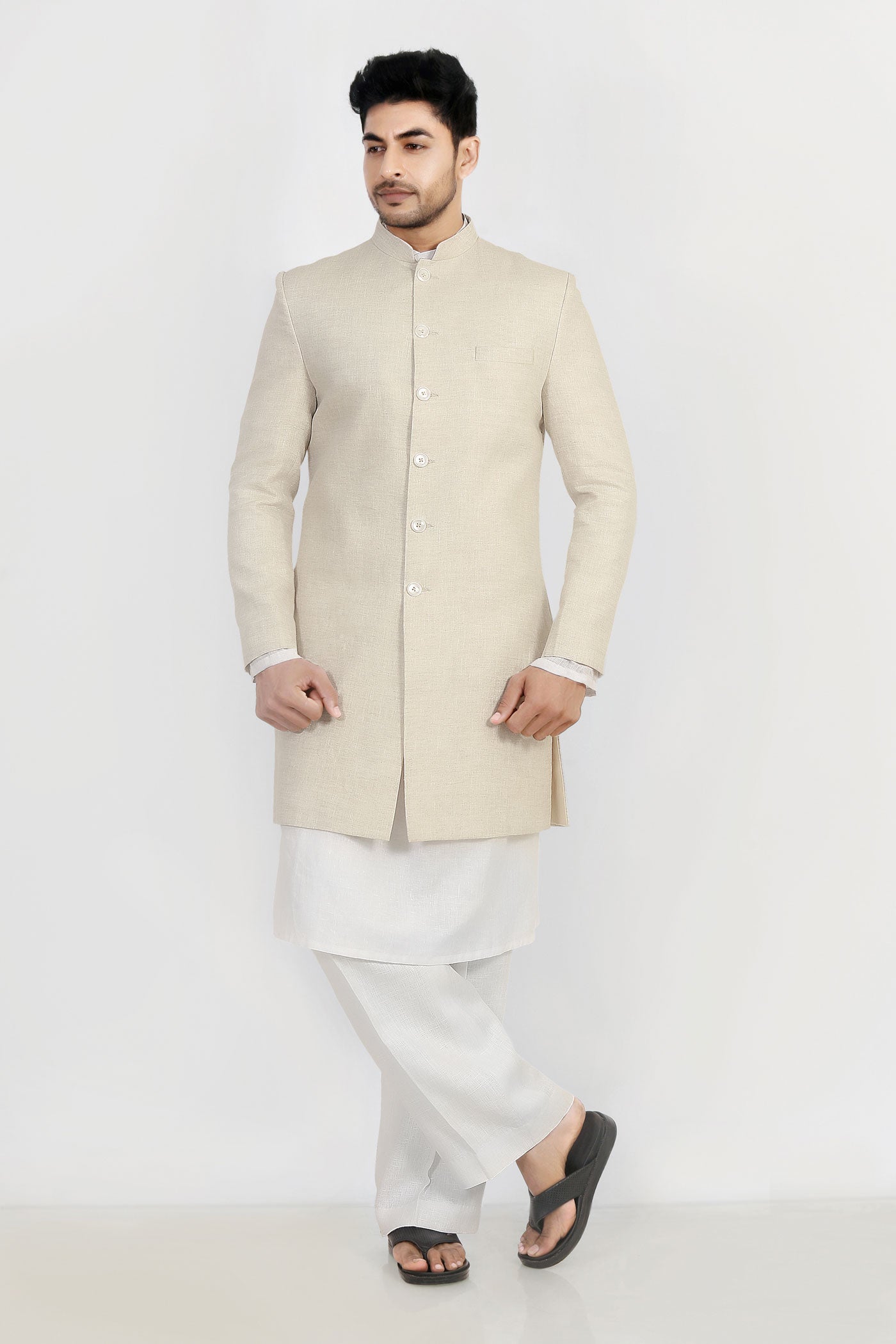 A man wearing a beige linen trench coat with a mandarin collar and chest pocket, standing against a white background.