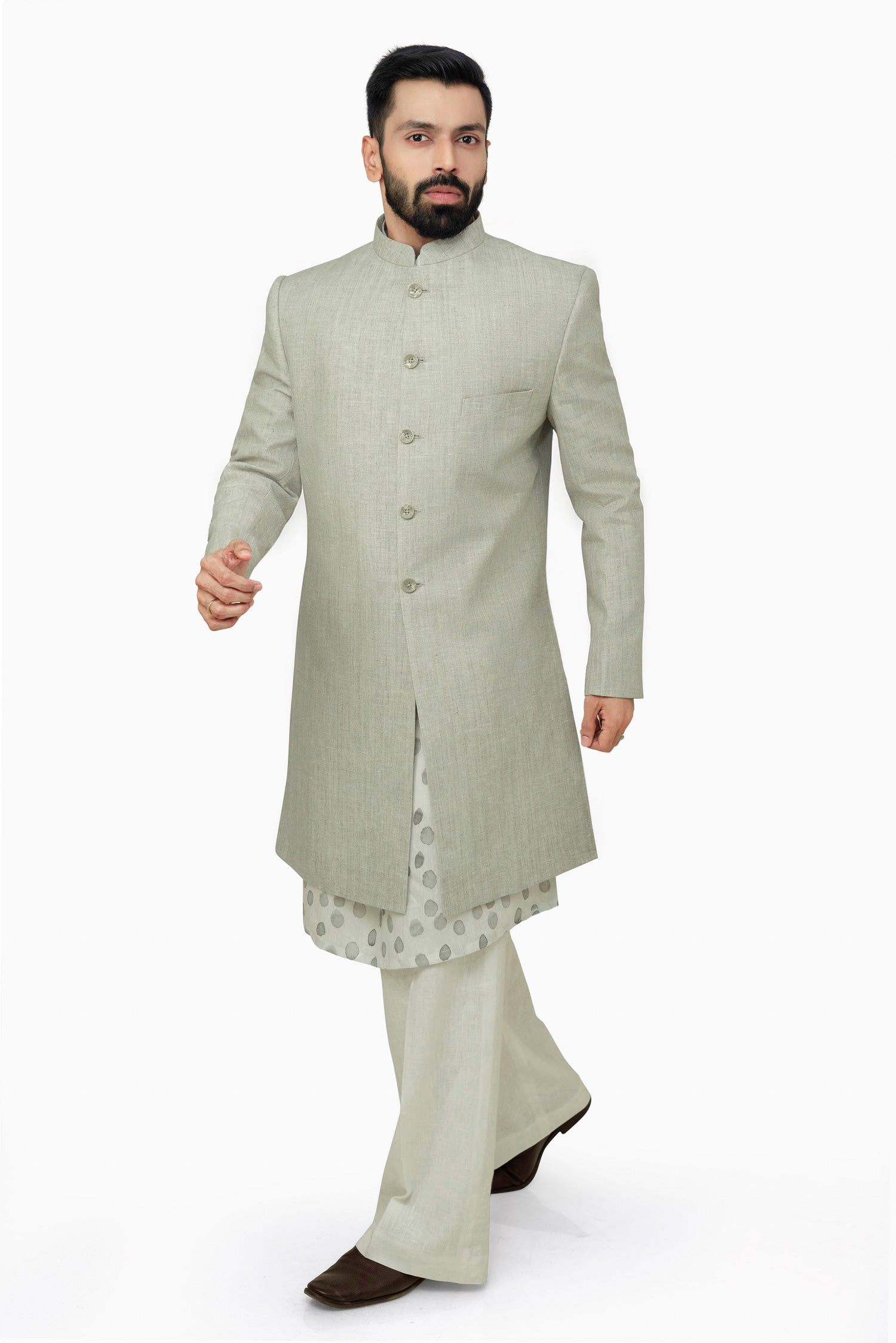 A male model wearing a grey Elm men's linen long coat with a mandarin collar, long sleeves, and front button closures. The coat is fully lined and has a straight fit.