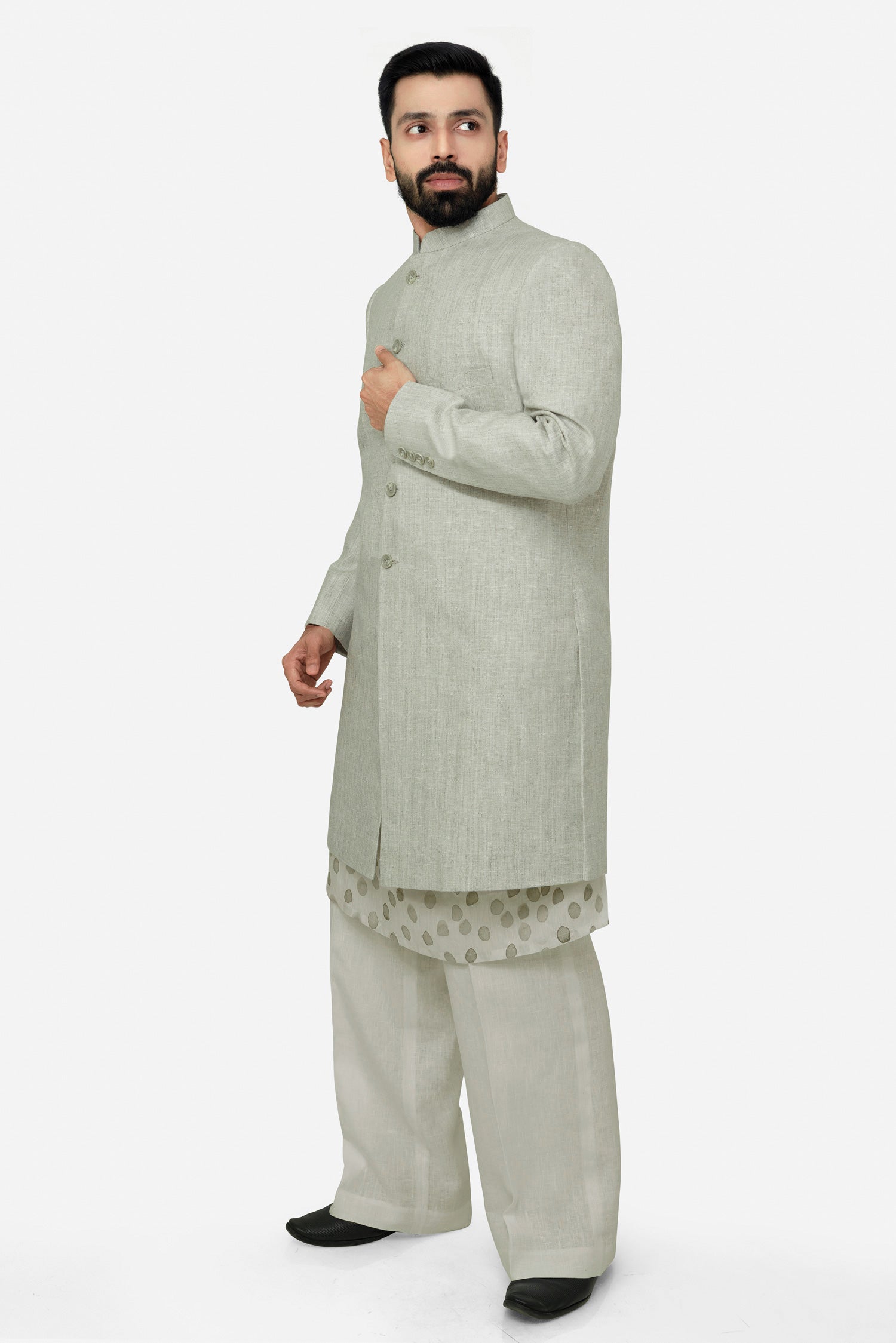 A male model wearing a grey Elm men's linen long coat with a mandarin collar, long sleeves, and front button closures. The coat is fully lined and has a straight fit.