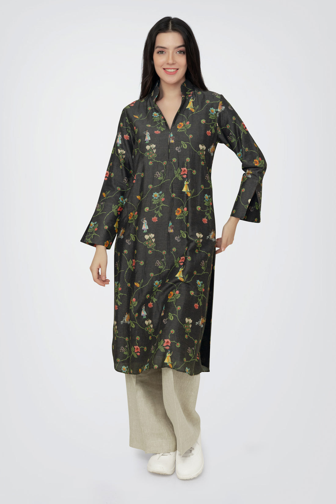 A woman standing against a white background, wearing a floral print long sleeve kurta with a mandarin collar and a V-shaped neck.