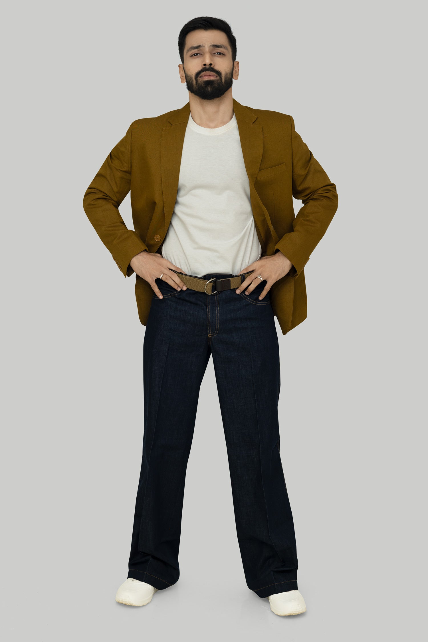 A male model wearing a crimson red linen blazer with a notch lapel, two-button opening, and functional sleeves.
