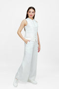 Woman wearing a white sleeveless top and wide-leg pants on a white background