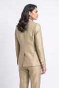A woman shown from the back wearing a tailored beige silk suit with a textured fabric, photographed against a clean white studio background.