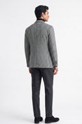 A man shown from the back wearing a black and white checks cotton blazer, dark gray trousers, and black shoes, photographed against a plain white studio background.