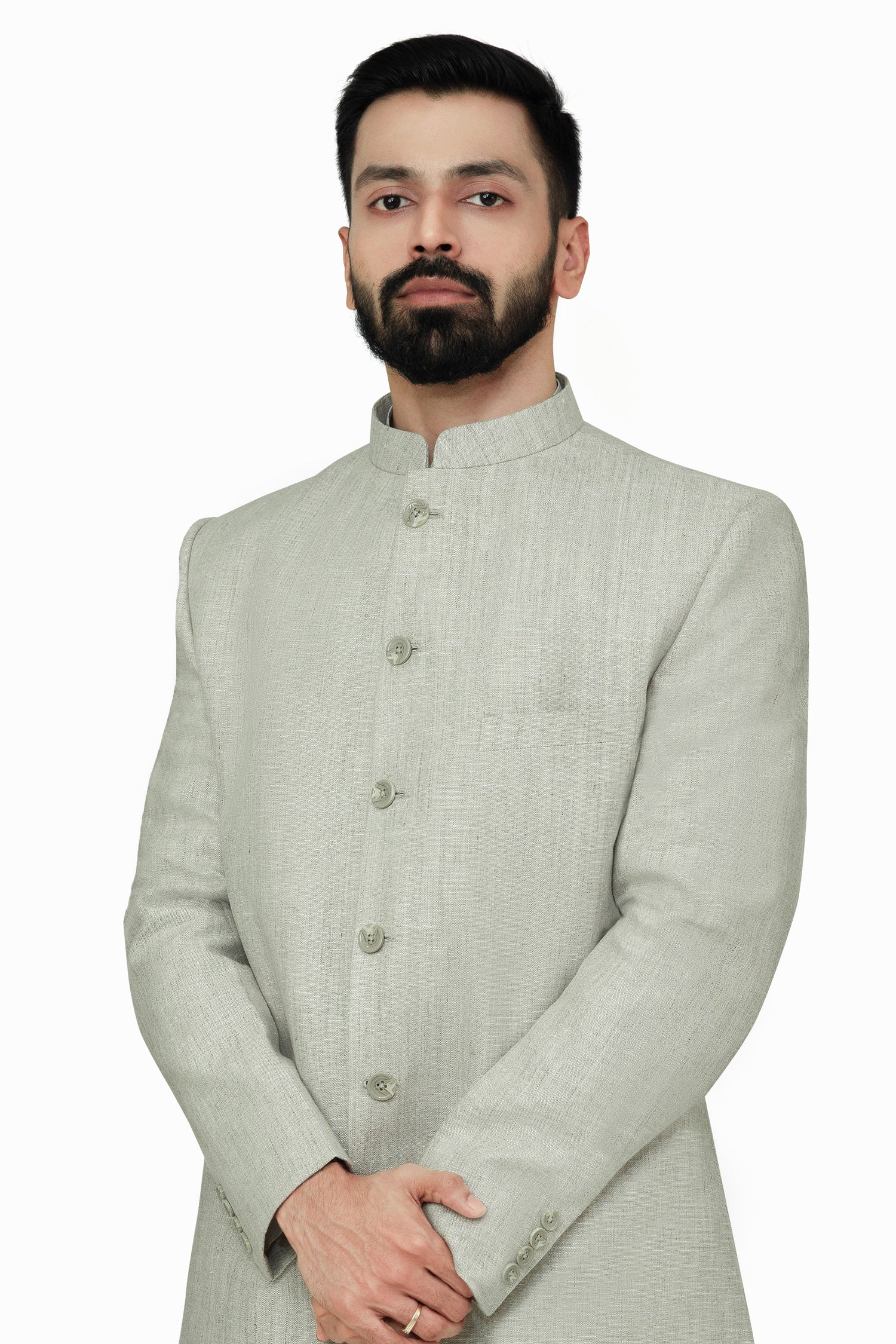 A male model wearing a grey Elm men's linen long coat with a mandarin collar, long sleeves, and front button closures. The coat is fully lined and has a straight fit.