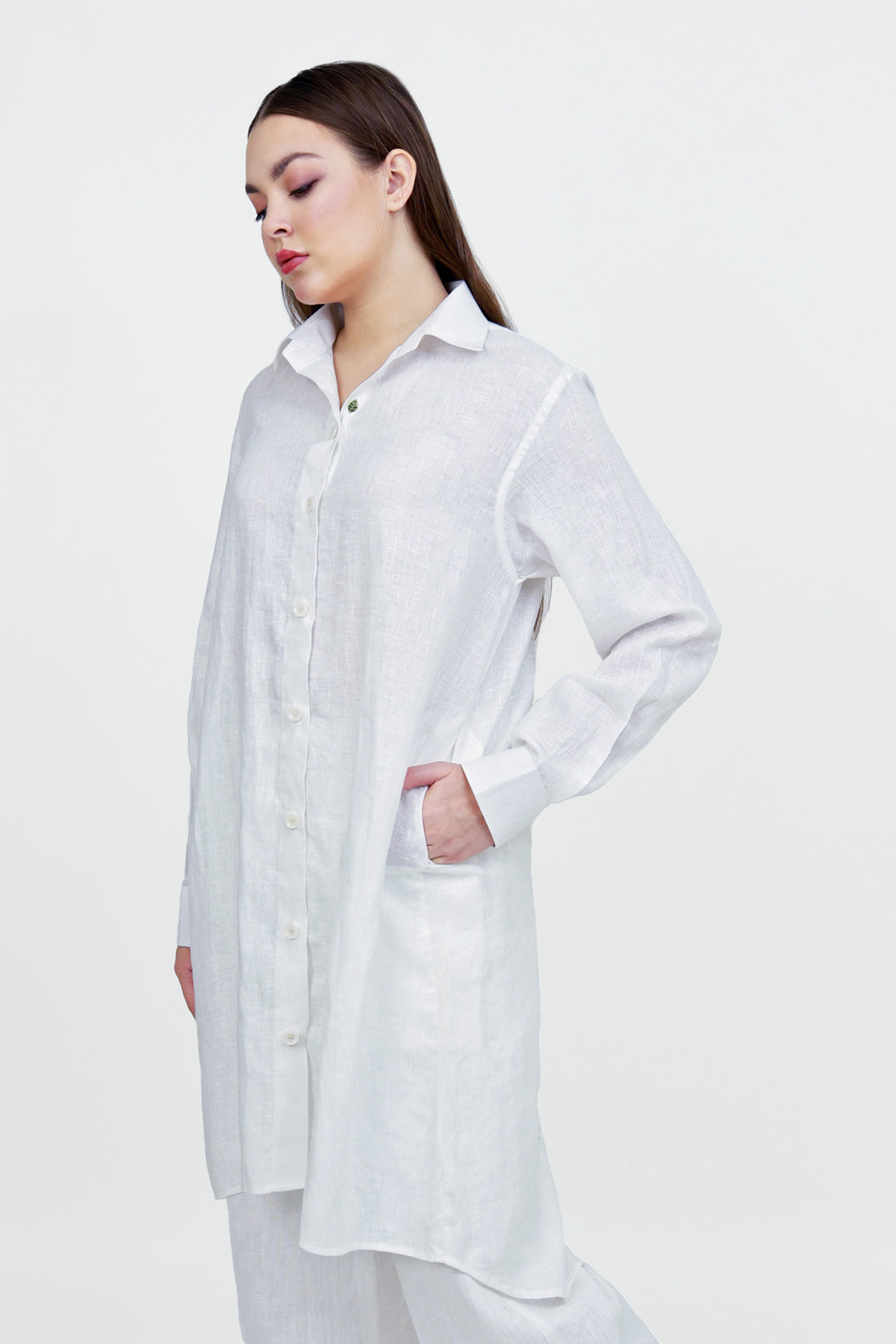 Woman wearing a long white shirt on a white background