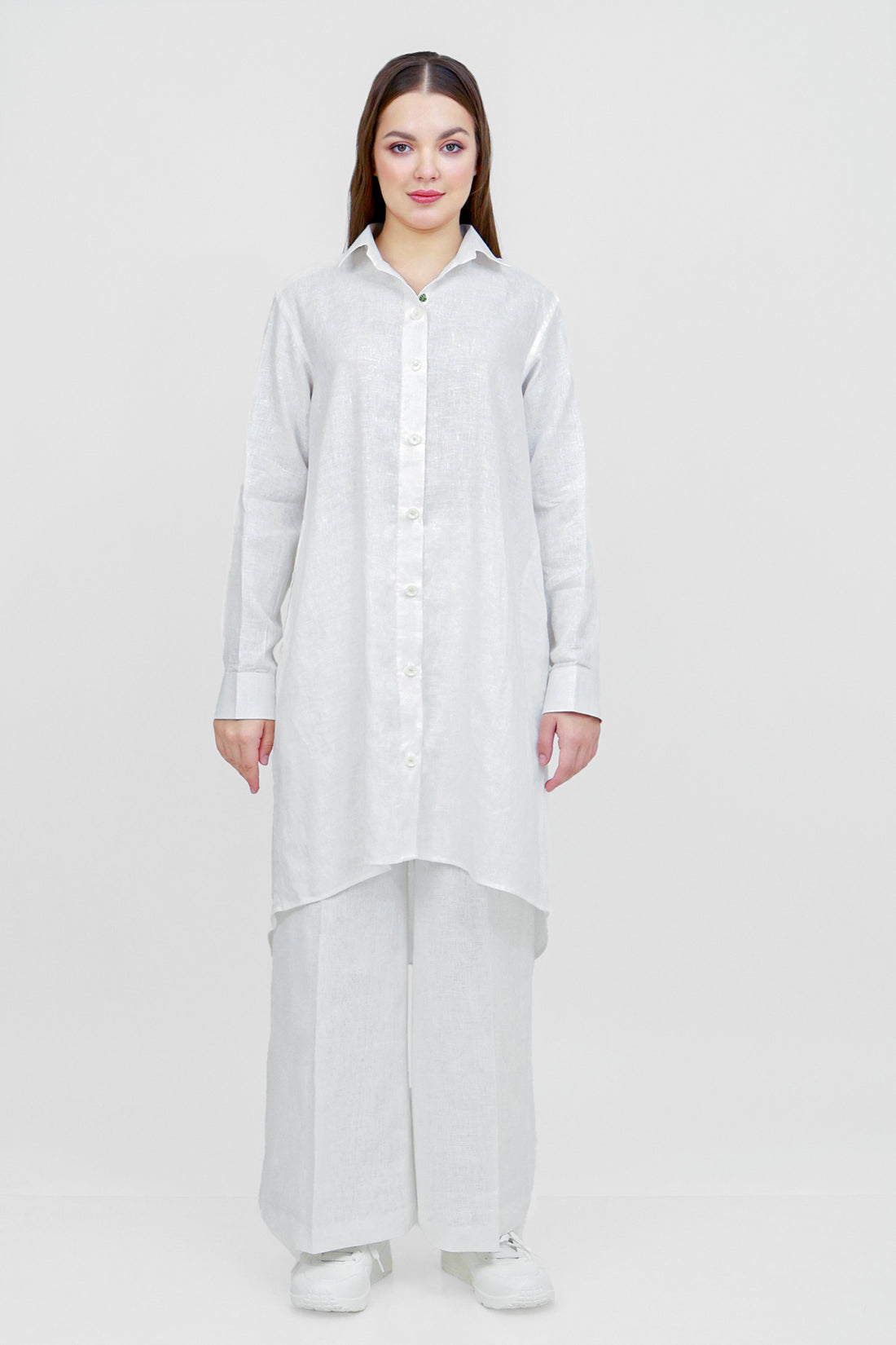 Woman wearing a long white shirt on a white background