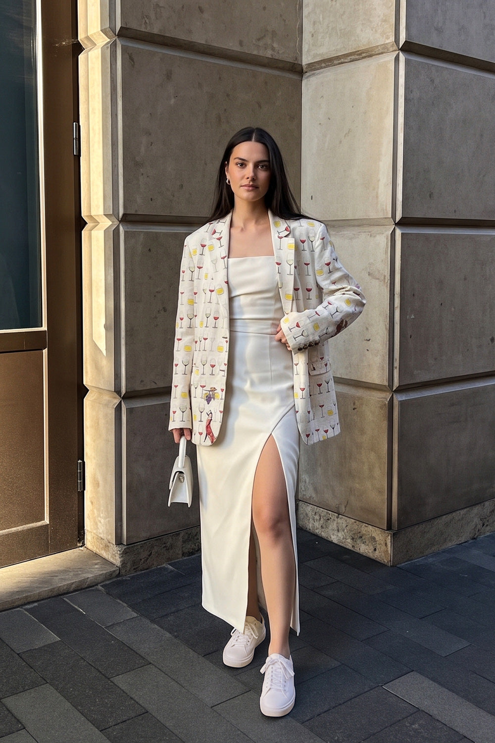Jam hemp boyfriend blazer worn over a cream slip dress with white sneakers, against a stone wall