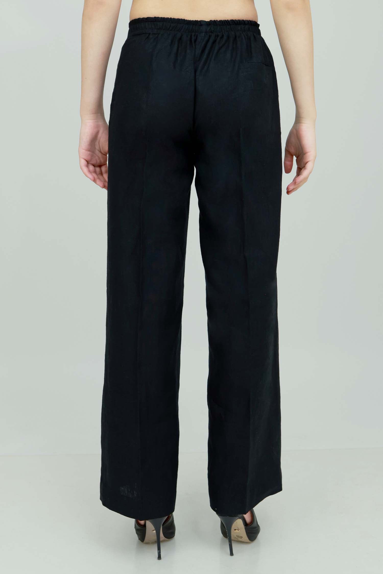 A pair of black wide-leg trousers with a mid-rise waist, front buttons, and a relaxed fit. The trousers are fully lined and have a hook and bar closure at the waistband with an adjustable elastic belt.
