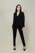 A woman modeling a black linen blazer with a notch lapel, two-button single-breasted design, and flap pockets.