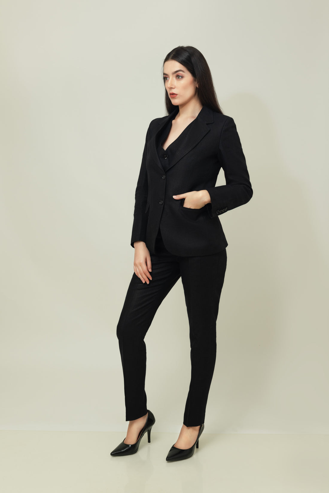 A woman modeling a black linen blazer with a notch lapel, two-button single-breasted design, and flap pockets.