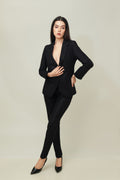 A woman modeling a black linen blazer with a notch lapel, two-button single-breasted design, and flap pockets.