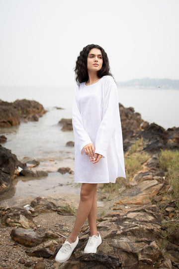 Women wearing white long top with long sleeves near beach