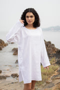 Women wearing white long top with long sleeves near beach