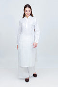 Woman wearing a long white dress against a white background