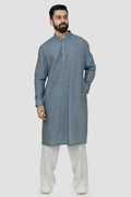 A man wearing a blue linen kurta with a mandarin collar, button placket at the waist, and side pockets. The kurta has a relaxed fit and side slits.
