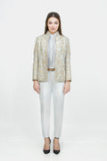 Woman wearing a gold patterned blazer, white shirt, and white pants on a white background