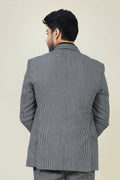 Stylish man in a gray and white checkered cotton jacket and pants, with a black shirt and white sneakers.